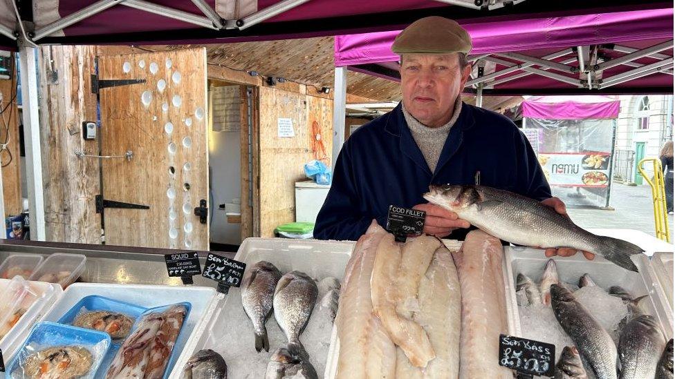 Tim Meads standing behind his fishmonger stall.