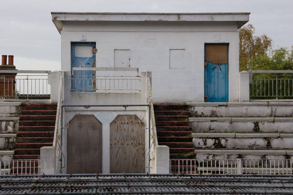 This is looking across from the sun terrace to the former poolside entrance to the ladies changing room. The metal structure at the bottom of the image is the main pool, which is covered by scaffolding for health and safety.