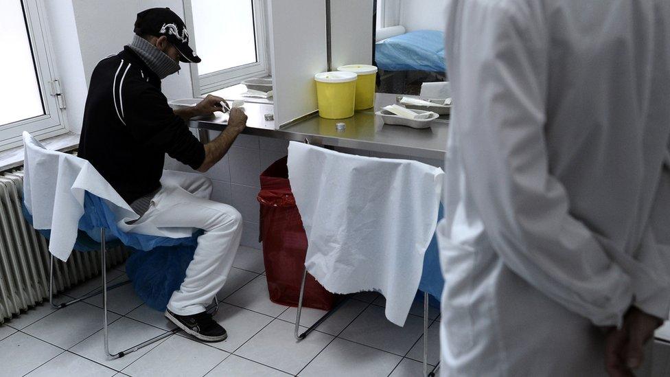 A man using drugs while a medic watches