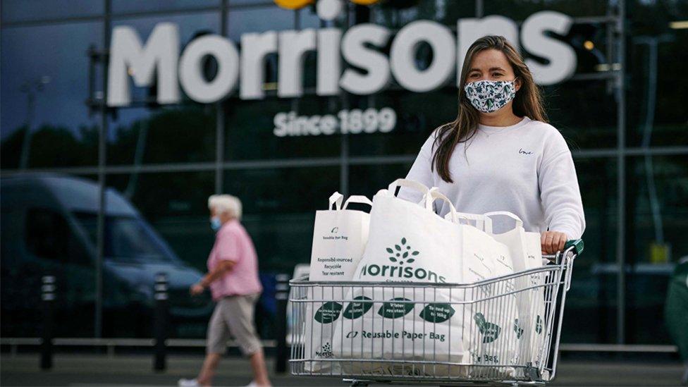 A woman with a supermarket trolley outside Morrisons