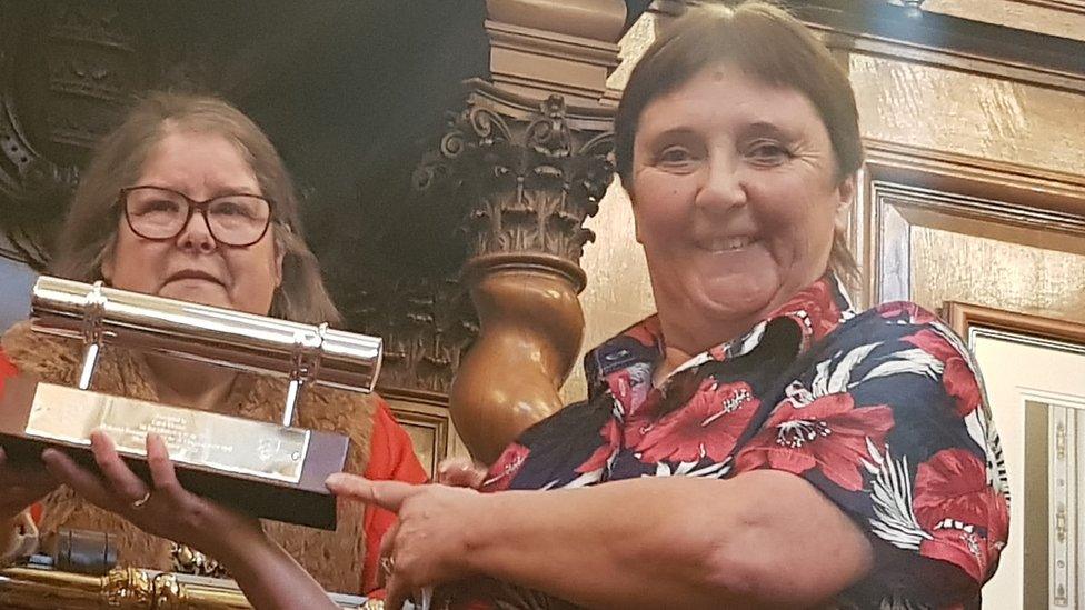 Carol Thomas being presented a trophy