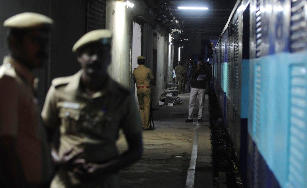 Indian police personnel stand guard alongside the Salem-Chennai Express train, which was robbed while in transit, at Egmore Railway station in Chennai on August 9, 2016. Some 50,000,000 INR, equivilent to approximately 749,000 USD, has been stolen from a moving train as it was being transported to the Reserve Bank of India, police said.