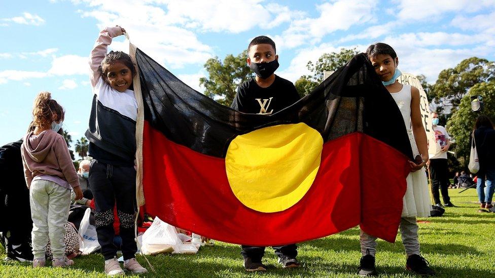 Children-holding-the-Aboriginal-flag.