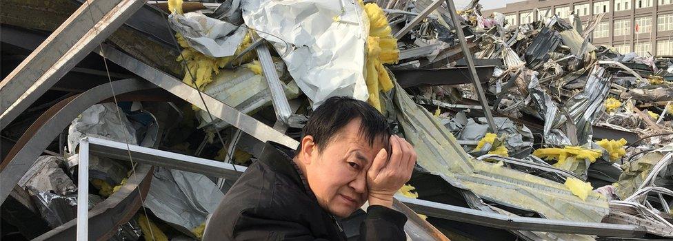 A migrant worker walks past debris at where buildings were demolished due to a citywide fire safety inspection prompted by a deadly fire in an apartment block, at Xinjiancun in Daxing district, in Beijing, China on 25 November 2017