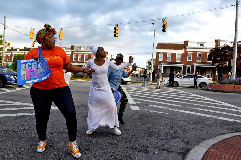 People dance in the street while holding signs that read "ceasefire" in Baltimore. Ceasefire is a local organization that stages events to call attention to the gun violence in Baltimore