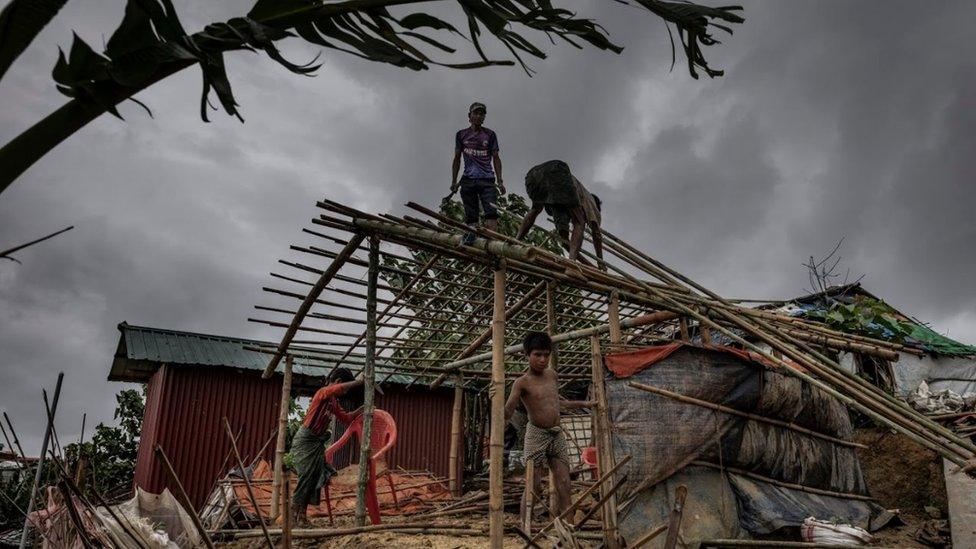 Men rebuilding a hut