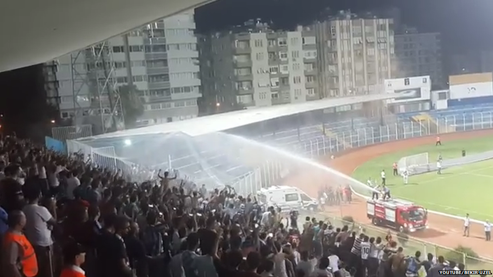 A view from the stands of the fire engine showering fans with water