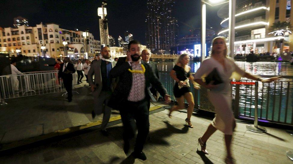 People run away as a fire engulfs the nearby The Address Hotel (not pictured) in downtown Dubai in the United Arab Emirates December 31, 2015