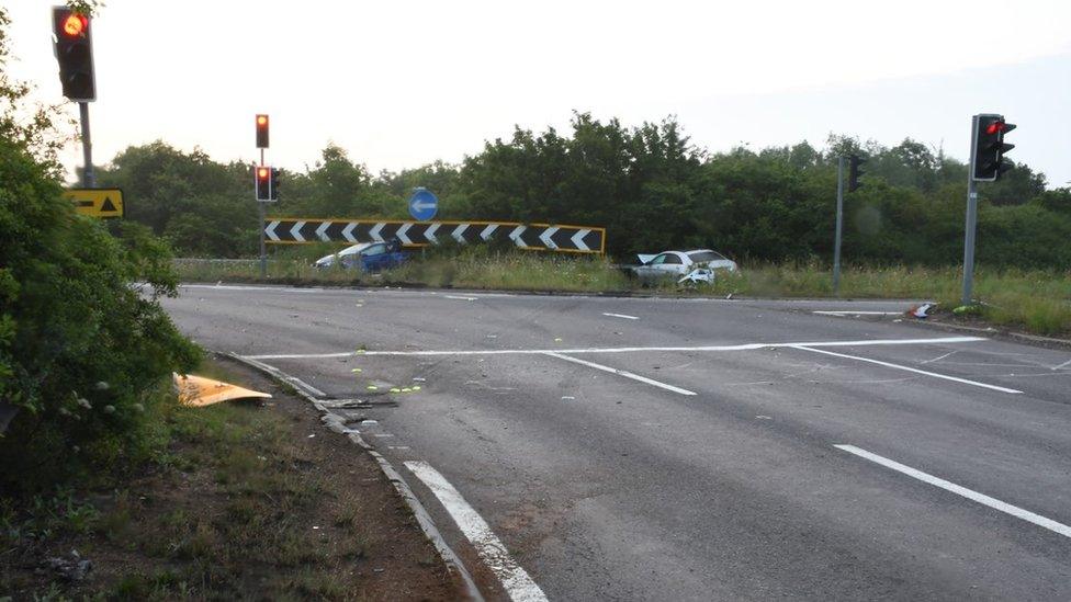 Honda Civic and silver Mercedes on roundabout island after crash, in police crime scene photograph