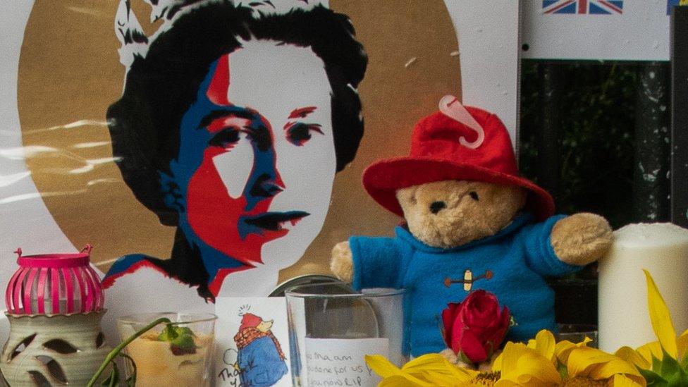 A Paddington Bear toy with a picture of the Queen and other tributes outside Cambridge Gate at Windsor Castle