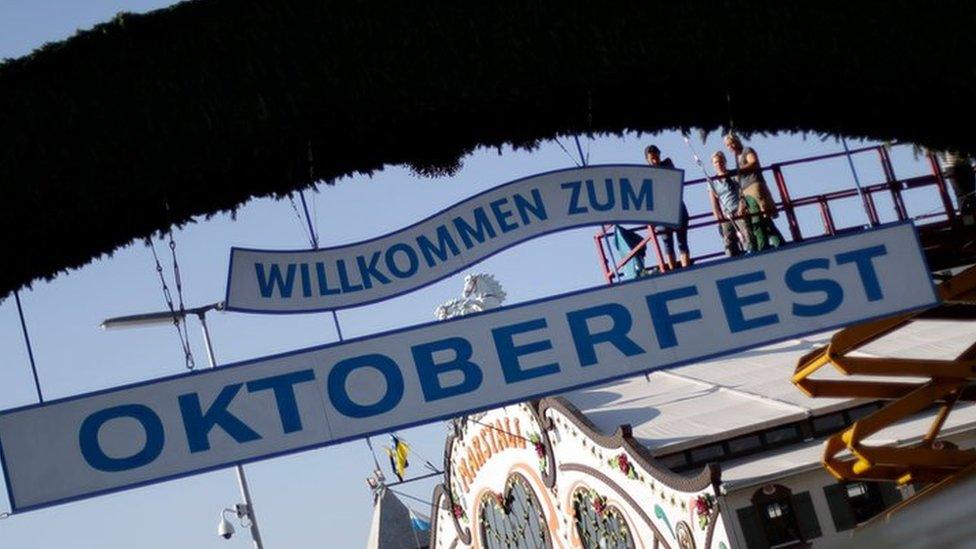 Employees prepare a sign at the main entrance of the "Theresienwiese", the area of the Oktoberfest, in Munich, Germany, Wednesday, Sept. 14, 2016