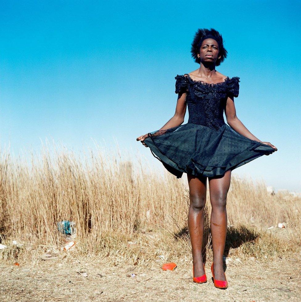 Person wearing black dress and red shoes