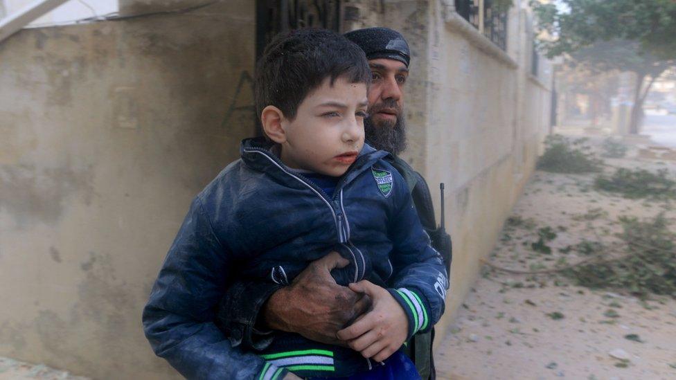 A rescue worker holds an injured boy after what activists said were airstrikes carried out by the Russian air force in Idlib