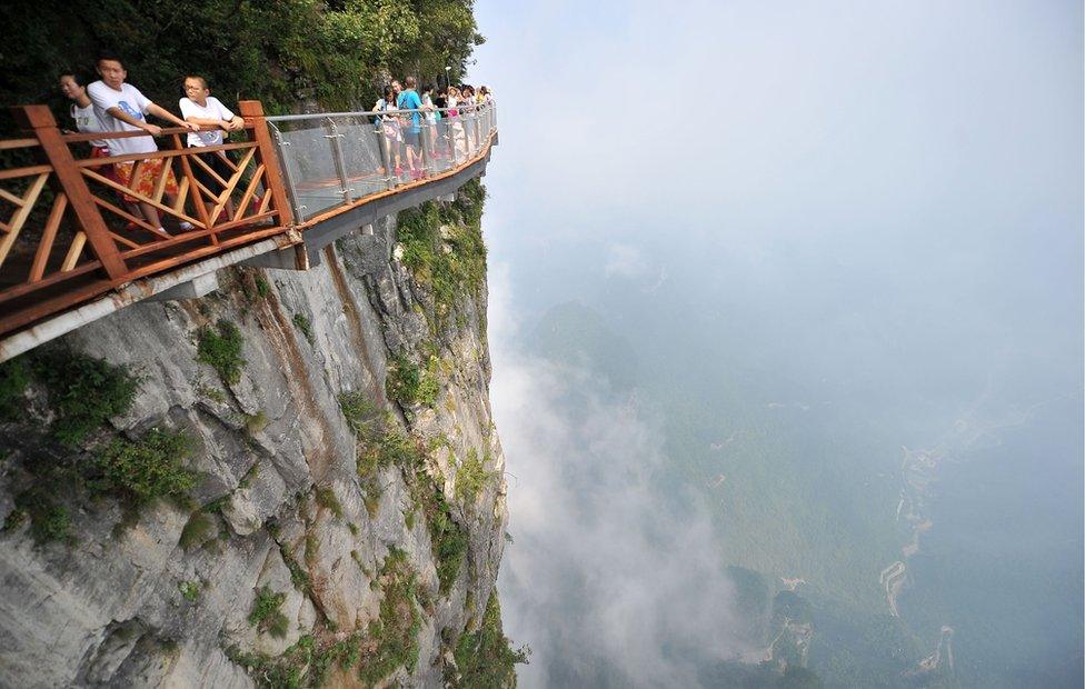 People walk around a glass walkway in Tianmen Mountain in Zhangjiajie National Forest Park, Hunan, China (1 August 2016)