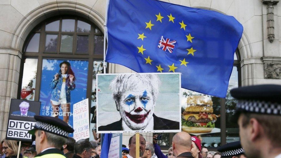 London protester holds up photo of Boris Johnson with clown's make-up, 19 October 2019