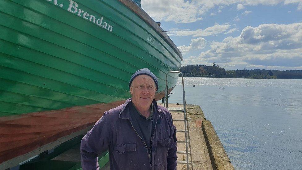 John Murray in front of his boat in Portaferry