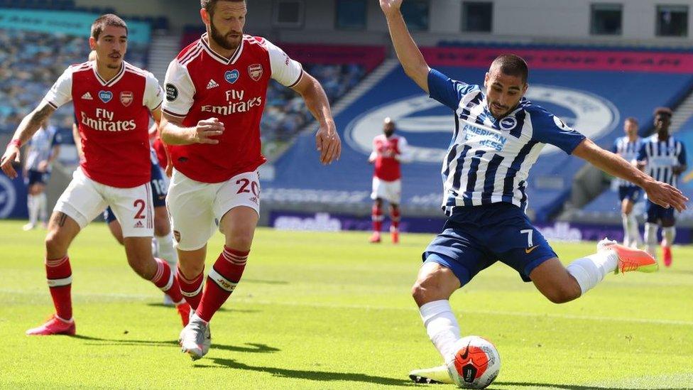 Neal Maupay kicking the ball for Brighton against Arsenal in a 2020 match played without spectators