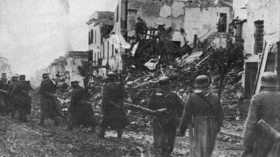 German troops walk past destroyed buildings in Battle of Anzio