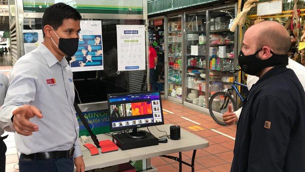 Customers walk past artificial intelligence cameras installed at entrances of Medellín, Colombia's Plaza Minorista market.