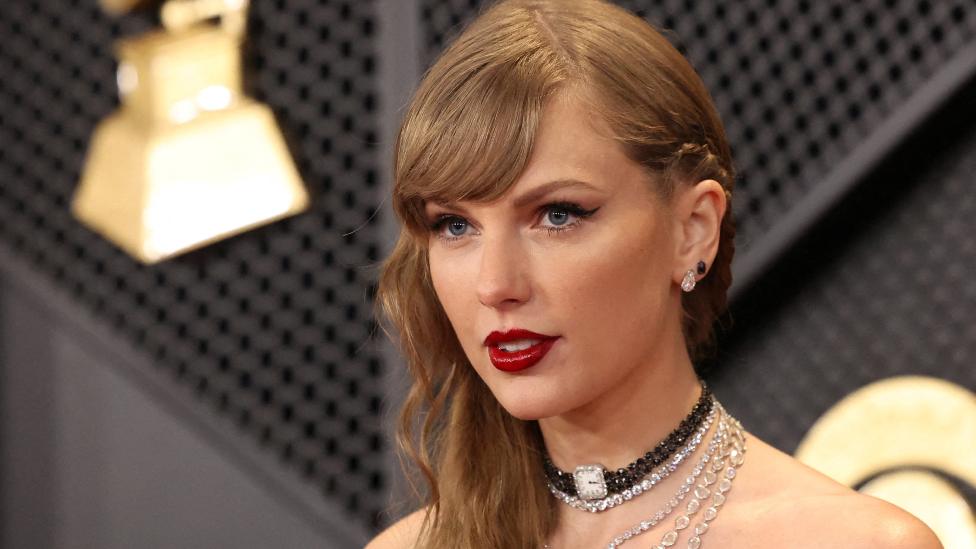 Taylor Swift poses on the red carpet as she attends the 66th Annual Grammy Awards in Los Angeles, California, U.S., February 4, 2024