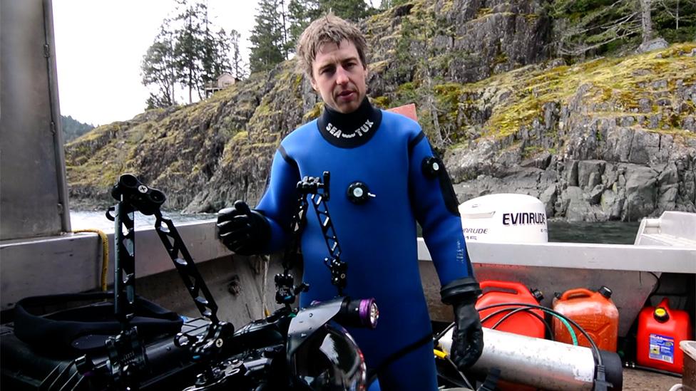 Photographer Tavish Campbell on his boat after diving to gather the effluent footage