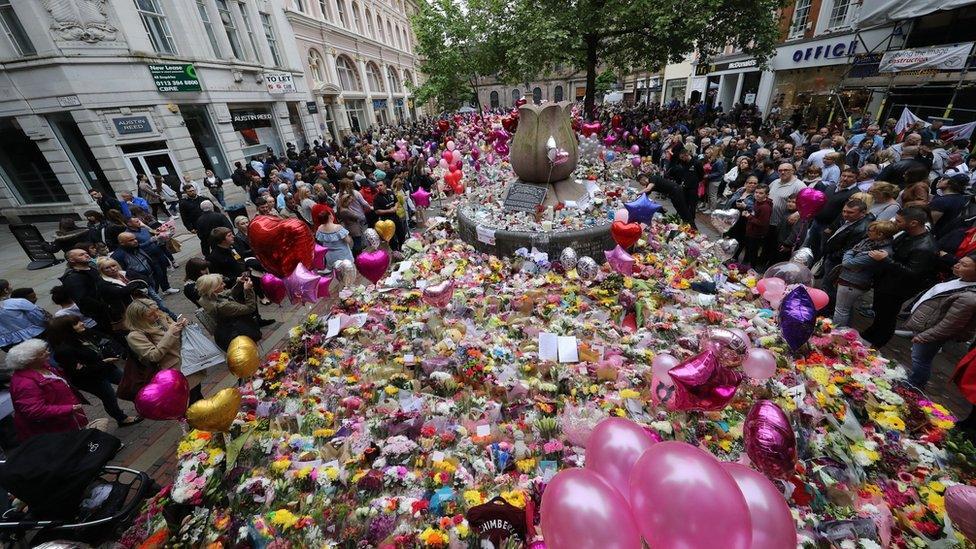 People leaving flowers in Manchester city centre one week after the Manchester Arena attack