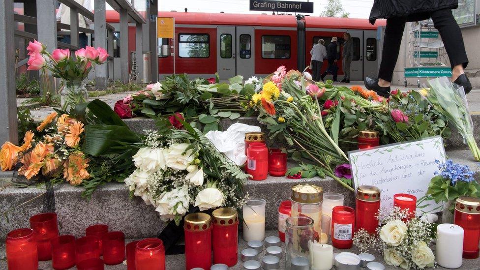 A condolence note, flowers and candles placed at the entrance to the railway station in Grafing near Munich, Germany, 11 May 2016.