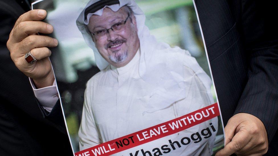 Someone holds up a sign with Khashoggi on it