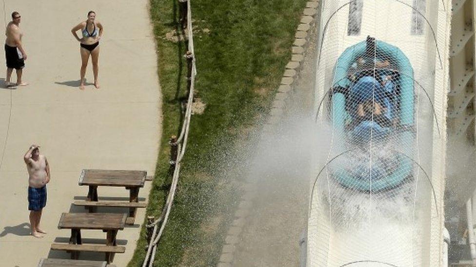 Raft descending Verrueckt waterslide as people watch