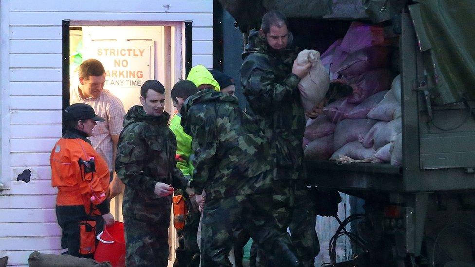 Members of the Army distribute sandbags and bail out water from shops in Donegal