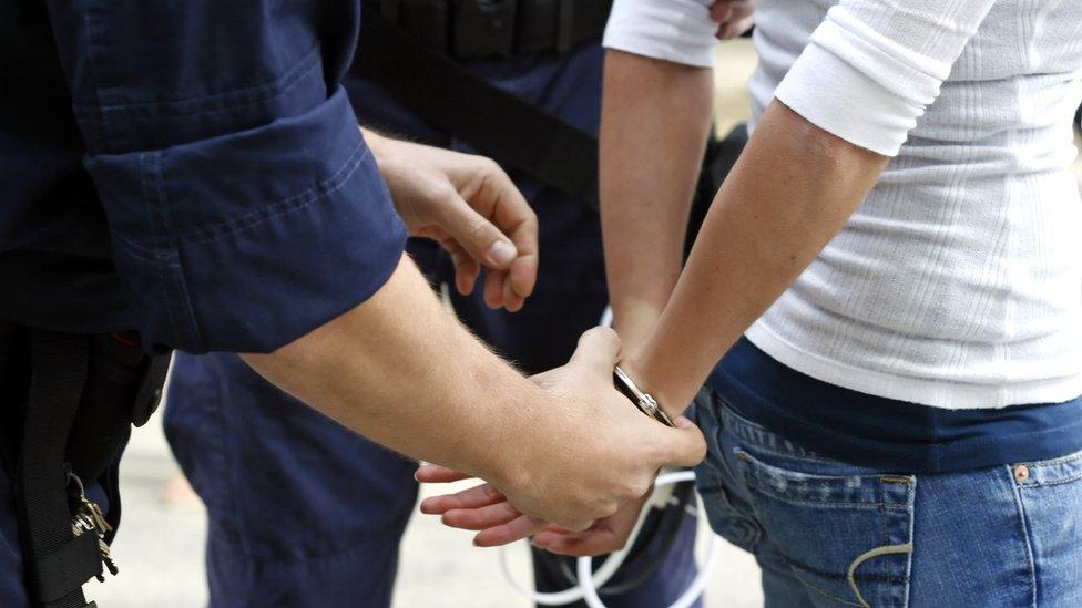 Stock image of a woman being handcuffed