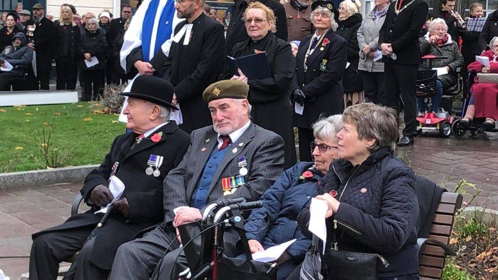 Ex-servicemen sitting on a bench at Ramsey war memorial