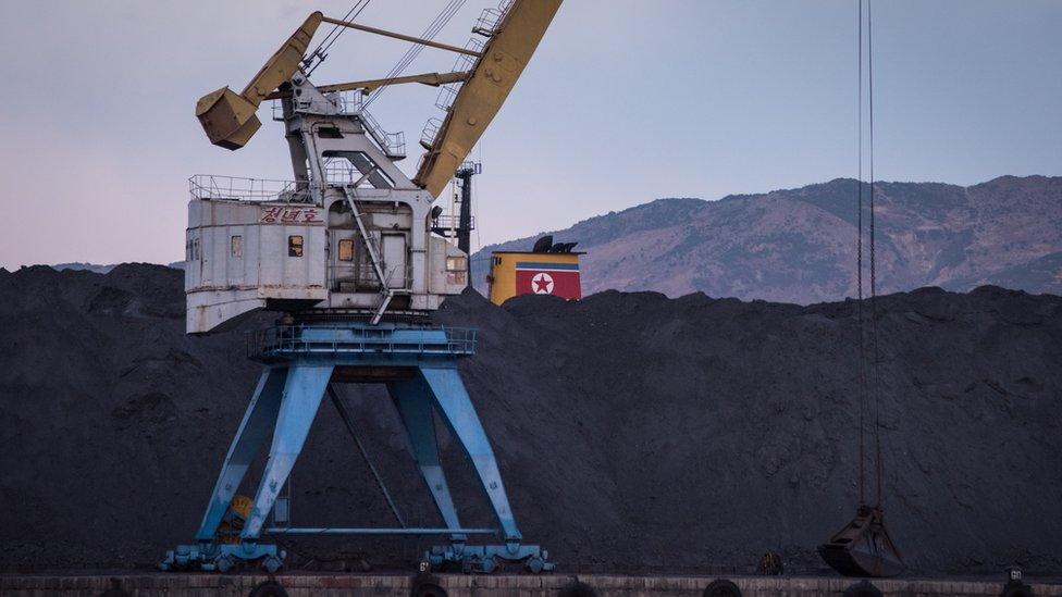 North Korean coal -- which would once have been bound for China -- is piled up on one side of the barrier in Rajin harbour, stranded by a UN ban on coal exports by Pyongyang