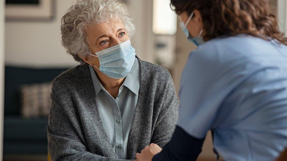 Woman in a mask with a health professional