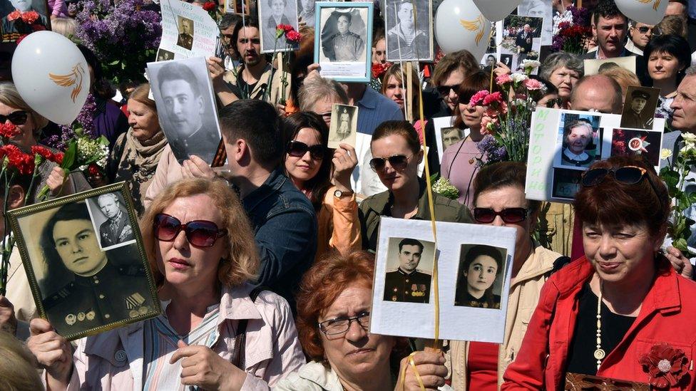 People hold portraits of their relatives and participants during the Immortal Regiment march in the Ukrainian capital of Kiev on May 9, 2016