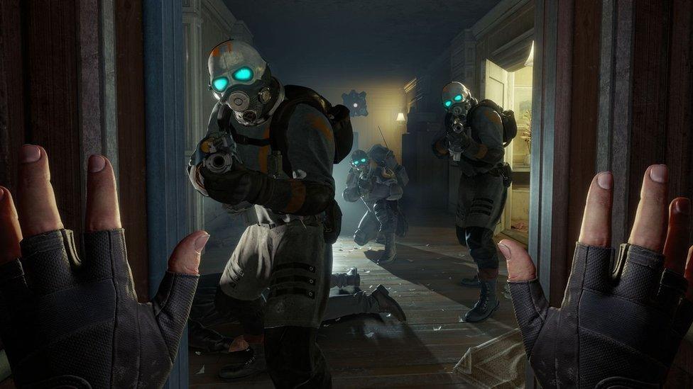 A screenshot from Valve's VR title Half-Life: Alyx, showing a first-person view of someone raising their hands in front of heavily-armed soldiers