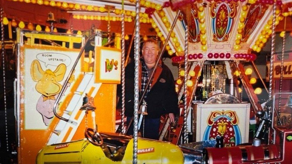 Roger Austin standing in the middle of a fairground ride