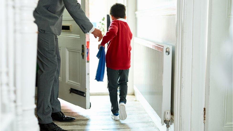 Boy going out of his door to school