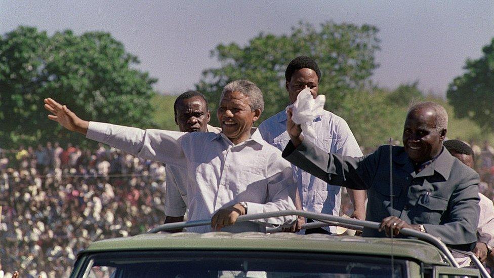 South African anti-apartheid leader and African National Congress (ANC) member Nelson Mandela (L) and Zambian President Kenneth Kaunda (R) wave to the crowd as they arrive at a mass rally of ANC, at Independent Stadium, 03 March 1990 in Lusaka, seat of the exiled ANC. Nelson Mandela, who was released from jail 11 February 1990, is in Zambia to attend a meeting of ANC National Executive Committee