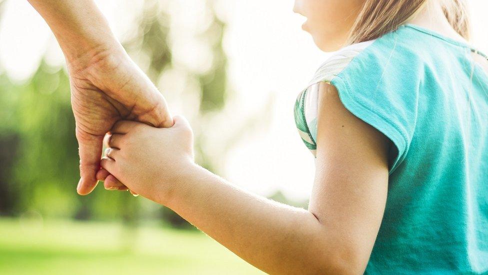 Child holding parent's hand