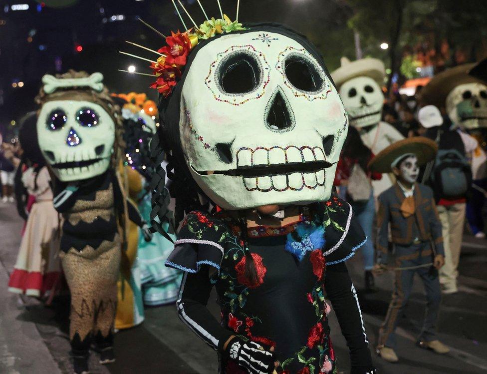 People dressed in costumes participate in the Catrinas procession as part of the celebrations for the Day of the Dead, in Mexico City, Mexico, 22 October 2023.