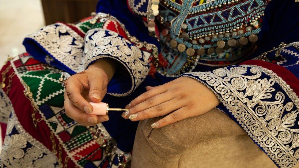 A woman putting on nail polish