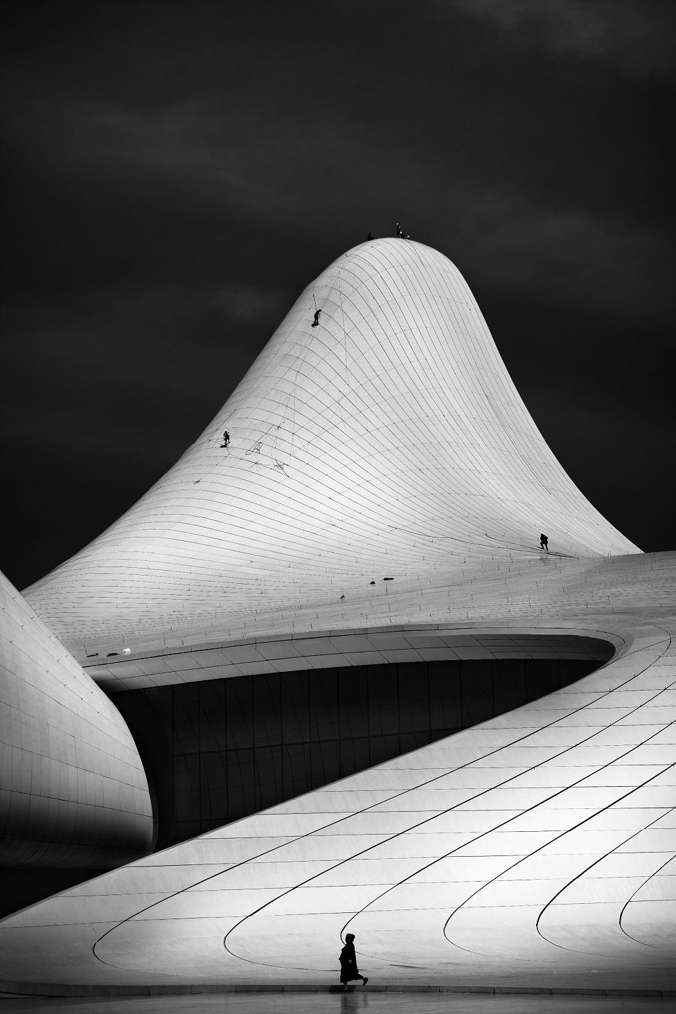 A black and white photo of a curved building