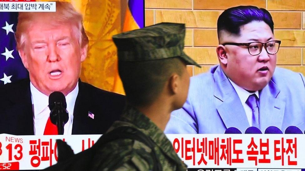 Donald Trump and Kim Jong-un on a big TV screen