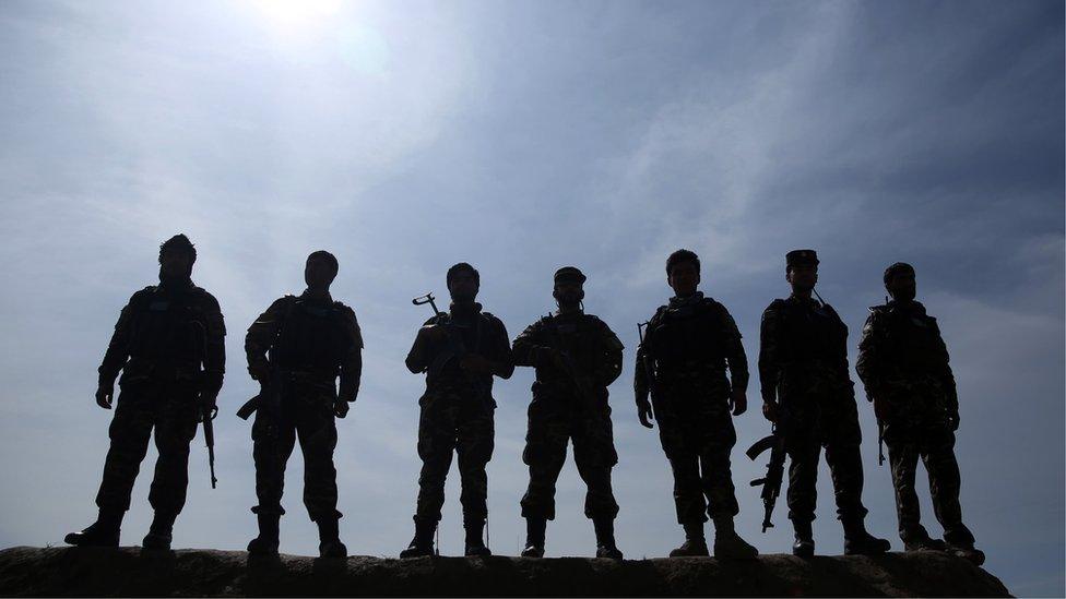 Afghan security forces stand guard after heavy clashes to recapture an area from Taliban militants in north of Kabul, Afghanistan on 15 March