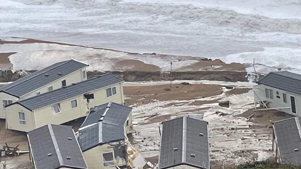 Scattered mobile homes in flood water at Burton Bradstock