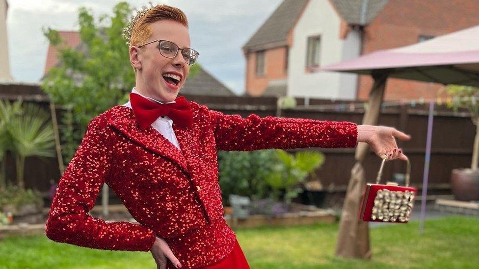 Korben in crown, giant bow tie and sequined jacket