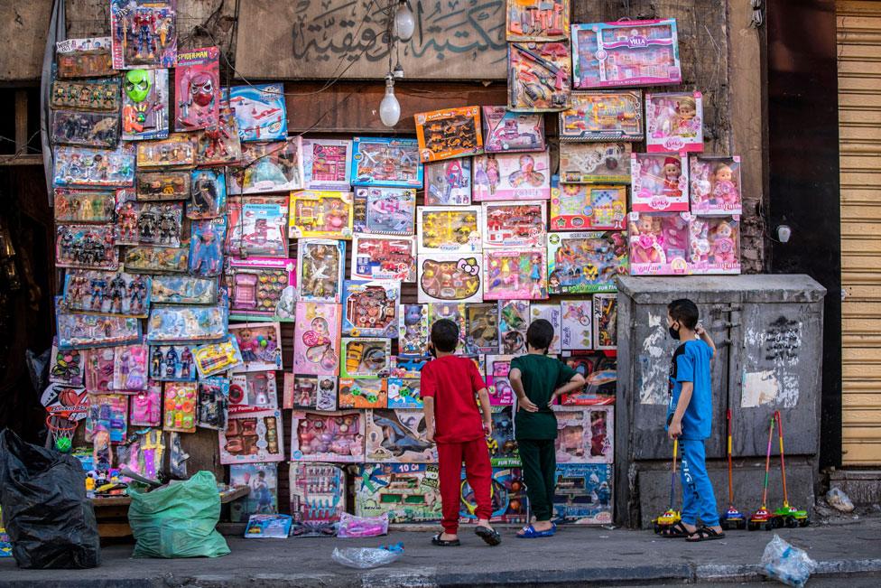 Children look at toys in the street following Eid al-Fitr prayers in Cairo