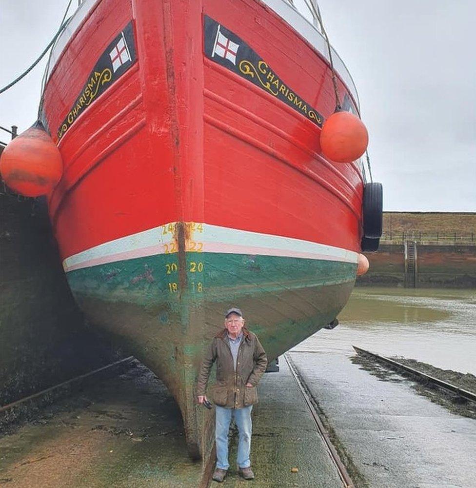 Man standing in front of the fishing boat Charisma