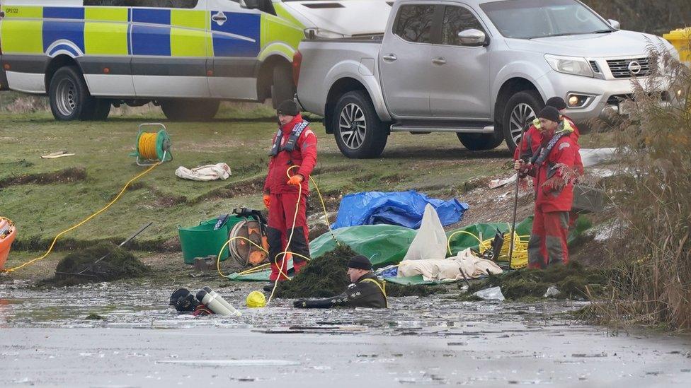 Divers searching lake